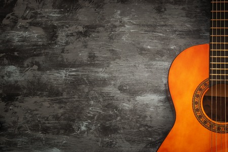 Close up of acoustic guitar against a wooden background.の写真素材