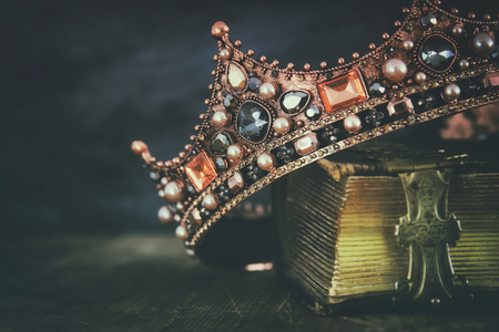 low key image of beautiful queen/king crown on old book. vintage filtered. fantasy medieval periodの写真素材