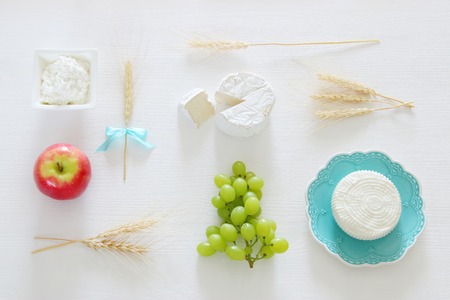 Top view image of dairy products and fruits on white wooden background. Symbols of jewish holiday - Shavuotの写真素材