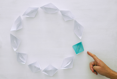 leadership concept, blue paper boat leading followers over white wooden background. top view. Retro filteredの写真素材
