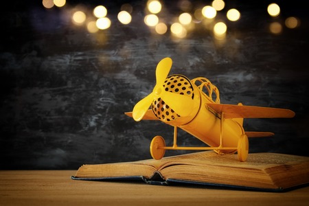 Toy plane and the open book on wooden tableの写真素材