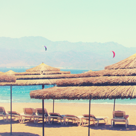 Photo of tropical sea and beach chairs under umbrellas. Summer travel and vacation conceptの写真素材