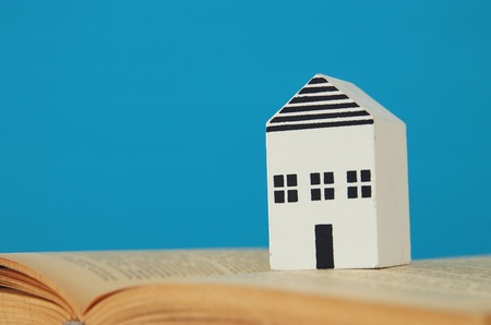 small house model over open book. selective focus.