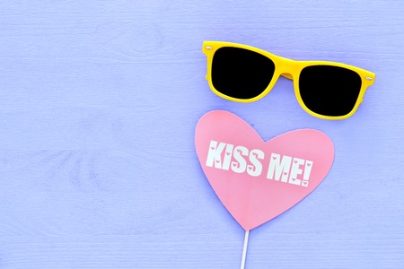 image of cute yellow black sunglasses and heart sign over purple wooden backgroundの写真素材