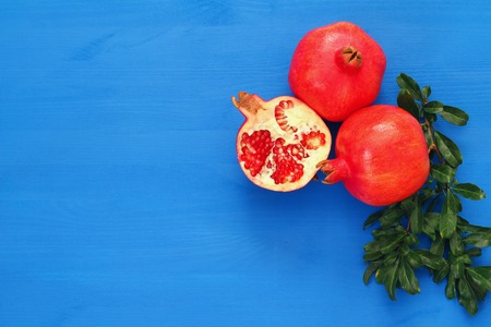 Rosh hashanah (jewesh New Year holiday) concept - pomegranate over wooden blue background. Traditional symbolの写真素材