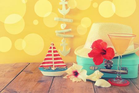 Fedora hat, tropical hibiscus flower on wooden table. relaxation or vacation concept.の写真素材