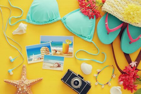 Top view of fashion female swimsuit bikini on yellow wooden background. Summer beach vacation concept.の写真素材