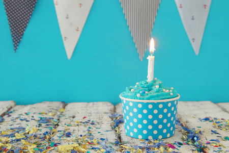 Birthday concept with cupcake and candle on wooden table.の写真素材