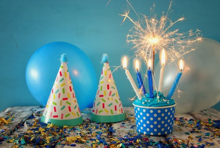 Birthday concept with cupcake and candles on wooden table.の写真素材