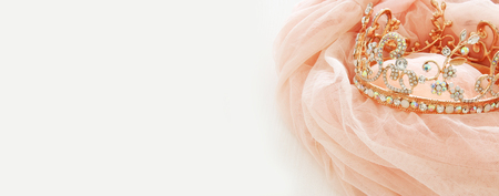 Vintage tulle pink chiffon dress and diamond tiara on wooden white table. Wedding and girl's party concept.の写真素材