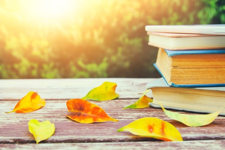 stack of old books on wooden table outdoors at afternoon. selective focusの写真素材