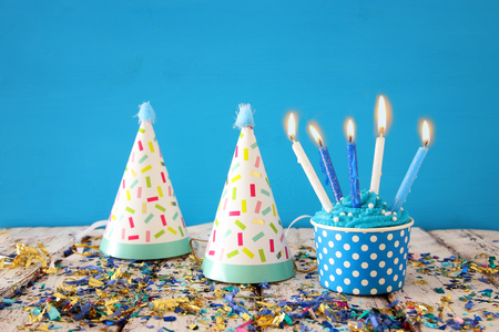 Birthday concept with cupcake and candles on wooden table.の写真素材