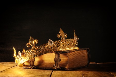 low key image of beautiful queen/king crown on old book. vintage filtered. fantasy medieval periodの写真素材
