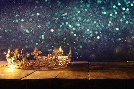 low key image of beautiful queen/king crown over wooden table. vintage filtered. fantasy medieval...