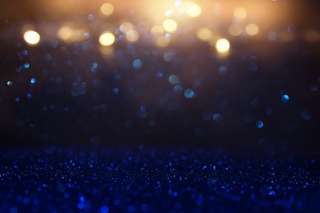glitter vintage lights background. blue, gold and black. de focused.