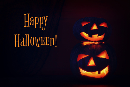 Halloween Pumpkin on wooden table in front of spooky dark background. Jack o lantern.の写真素材