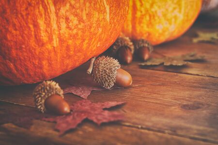 Pumpkins and autumn leaves on wooden table. thanksgiving and halloween concept.の写真素材