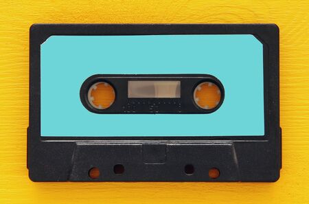 Retro cassette tape over yellow wooden table. top view. copy space.の写真素材