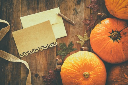 Pumpkins and autumn leaves on wooden background. thanksgiving and halloween concept. Top view.の写真素材