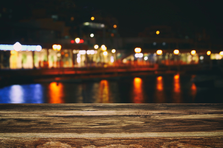 Image of wooden table in front of abstract blurred restaurant lights background.の写真素材