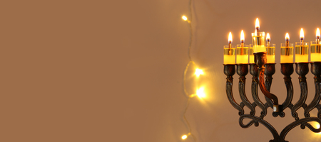 Low key image of jewish holiday Hanukkah background with menorah (traditional candelabra) and burning candlesの写真素材