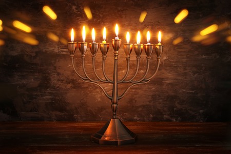 Low key image of jewish holiday Hanukkah background with menorah (traditional candelabra) and burning candles.の写真素材