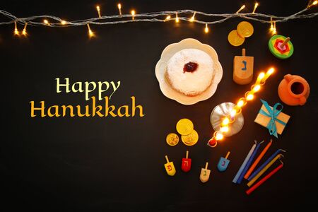 Top view image of jewish holiday Hanukkah background with traditional spinnig top, menorah (traditional candelabra) and burning candlesの写真素材