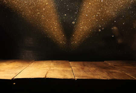 Empty table in front of black and gold glitter lights background. For product display montage