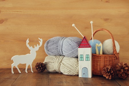warm and cozy yarn balls of wool on wooden tableの写真素材
