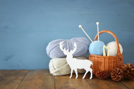 warm and cozy yarn balls of wool on wooden tableの写真素材