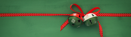 Christmas background with red silk traditional ribbon and jingle bellsの写真素材