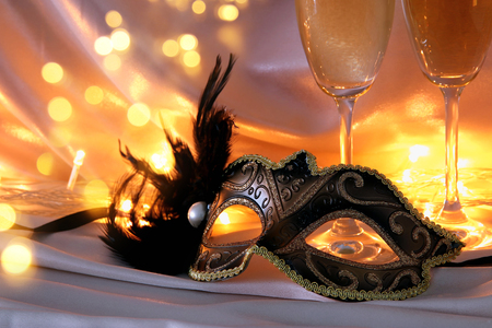Image of elegant venetian mask and glasses of champagne over gold silk backgroundの写真素材