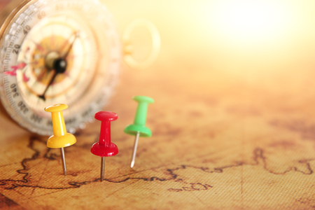 Image of pins attached to map, showing location or travel destination next to vintage compass. selective focusの写真素材