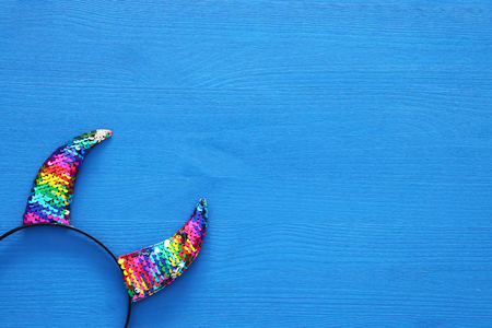 Top view image of carnival masquerade accessory: colorful and funny devil horns over wooden blue backgroundの写真素材