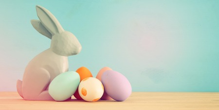 Cute bunny next to easter colorful eggs over colorful background