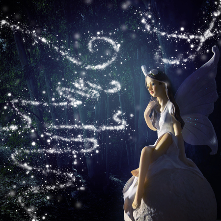 image of magical little fairy in the forest sitting over the stoneの写真素材