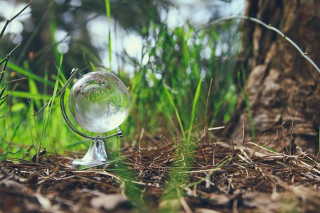 low angle small crystal globe in the grass. travel and global issues conceptの写真素材