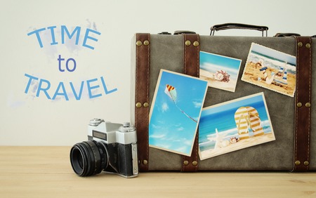 Image of old vintage luggage with vacation photos over wooden floorの写真素材