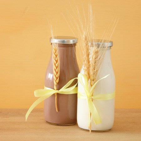 image of milk and Chocolatewith wheat over wooden table and pastel background. Symbols of jewish holiday - Shavuotの写真素材