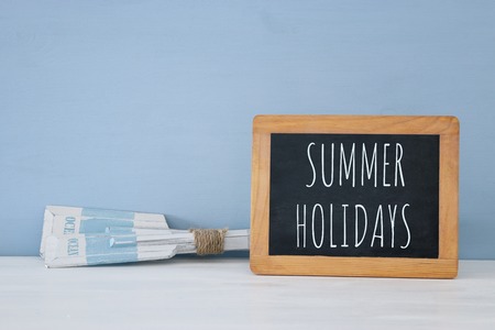 nautical concept with wooden decorative boat oars and blackboard over blue backgroundの写真素材