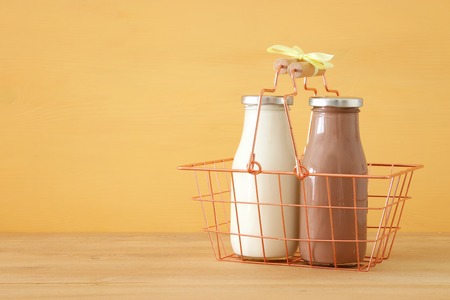 image of milk and Chocolate in the basket over wooden table and pastel background. Symbols of jewish holiday - Shavuotの写真素材