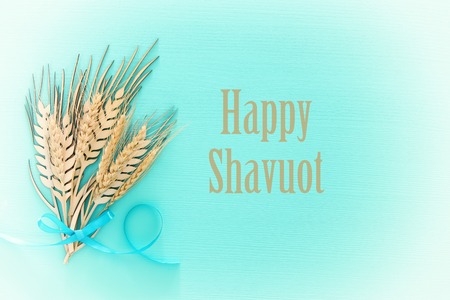 top view of wooden wheat crop decoration over mint background. Symbols of jewish holiday - Shavuot