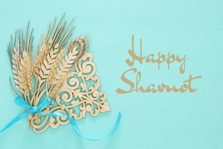 top view of wooden wheat crop decoration over mint background. Symbols of jewish holiday - Shavuotの写真素材