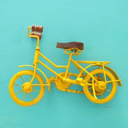 top view of vintage metal yellow bicycle toy over wooden backgroundの写真素材