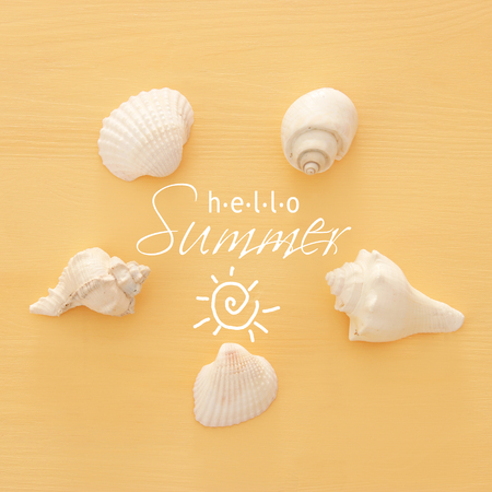 vacation and summer image with seashells over yellow wooden backgroundの写真素材