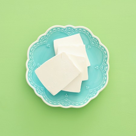 Top view image of bulgarian cheese over pastel wooden background. Symbols of jewish holiday -...