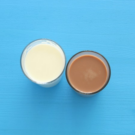 Top view image of chocolate and milk over pastel wooden background. Symbols of jewish holiday - Shavuotの写真素材