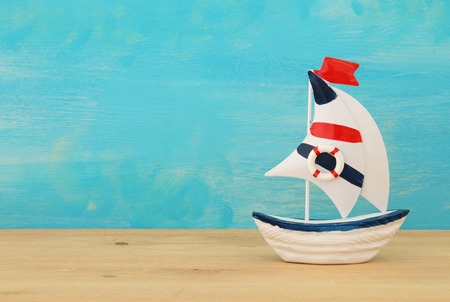 vacation and summer image with boat over wooden table