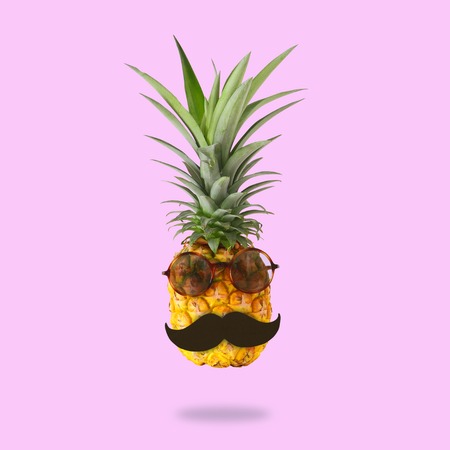 minimal concept. Cute and funny pineapple with sunglasses and mustache over pink background