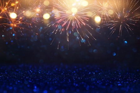 abstract gold, black and blue glitter background with fireworks. christmas eve, 4th of july holiday...